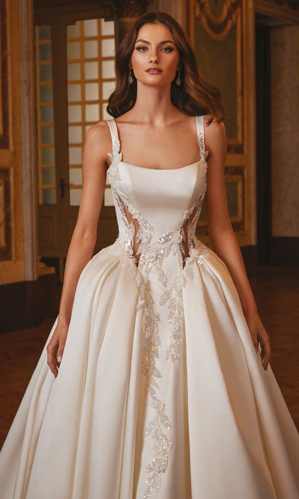 Atemberaubendes Brautkleid mit schimmernden Details und klassischer Silhouette, perfekt in einer königlichen Kulisse inszeniert.