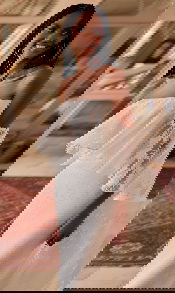 Braut in einem modernen, geblümten Spitzenkleid mit verspielten Glockenärmeln – ungezwungen und elegant zugleich.