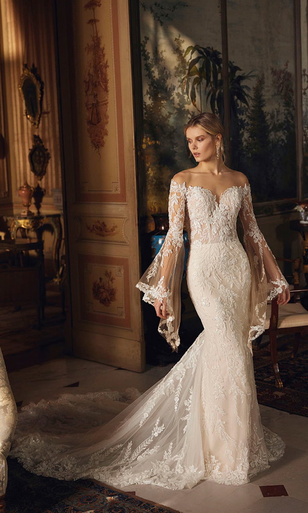 Sinnliches Hochzeitskleid mit Off-Shoulder-Spitzenärmeln und langer Schleppe in einem stilvollen Schlossinterieur.