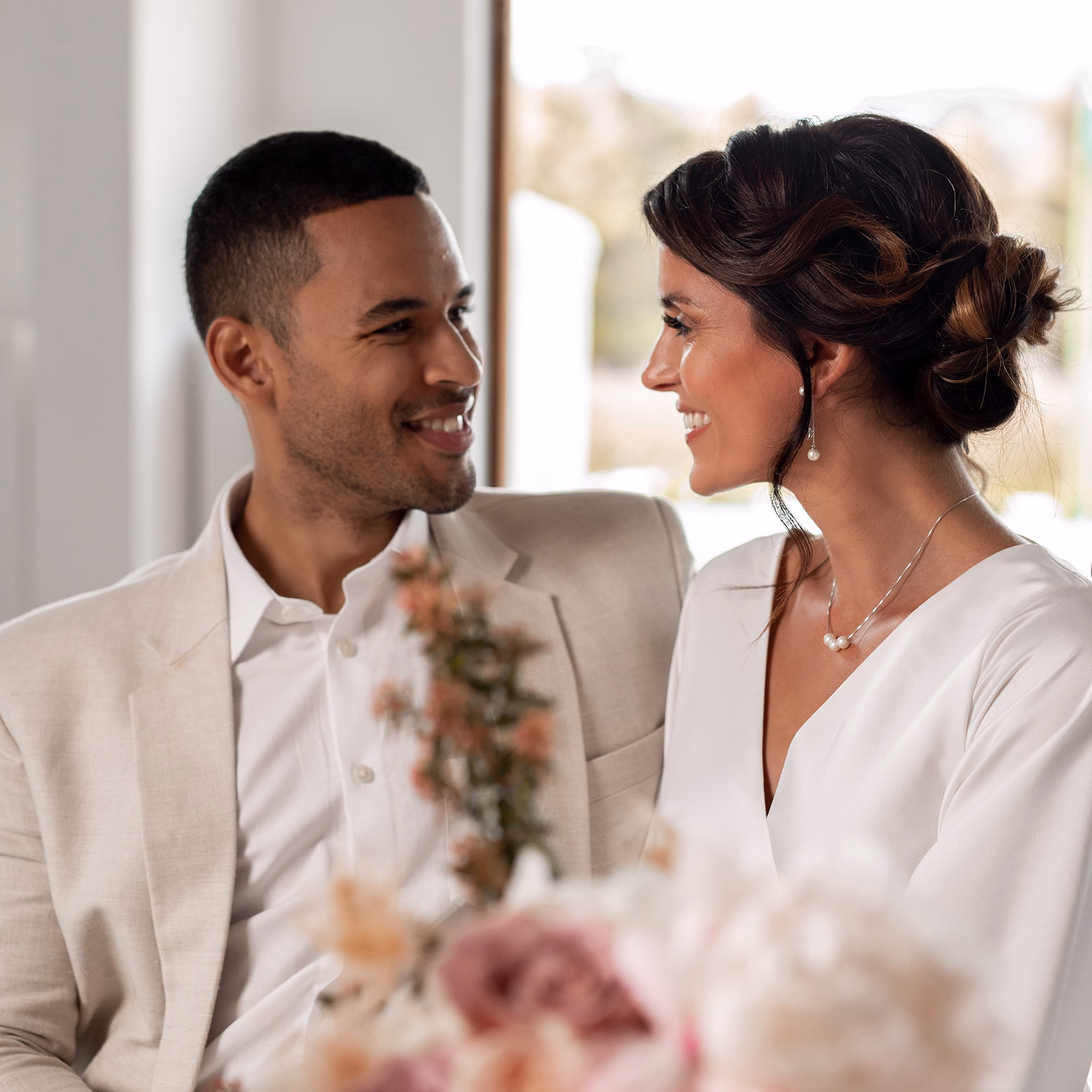 Glückliches Paar in stilvoller Hochzeitsmode – ein Blick voller Liebe und Vorfreude.