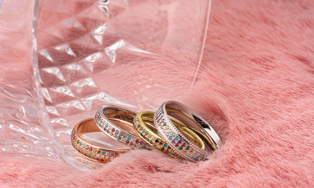 Gold- und Silberringe mit funkelnden Edelsteinen in einem eleganten und weichen Setting.