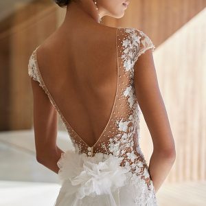 Feminin-verspieltes Brautkleid mit elegantem Blumendetail und transparentem Tüll auf dem Rücken.