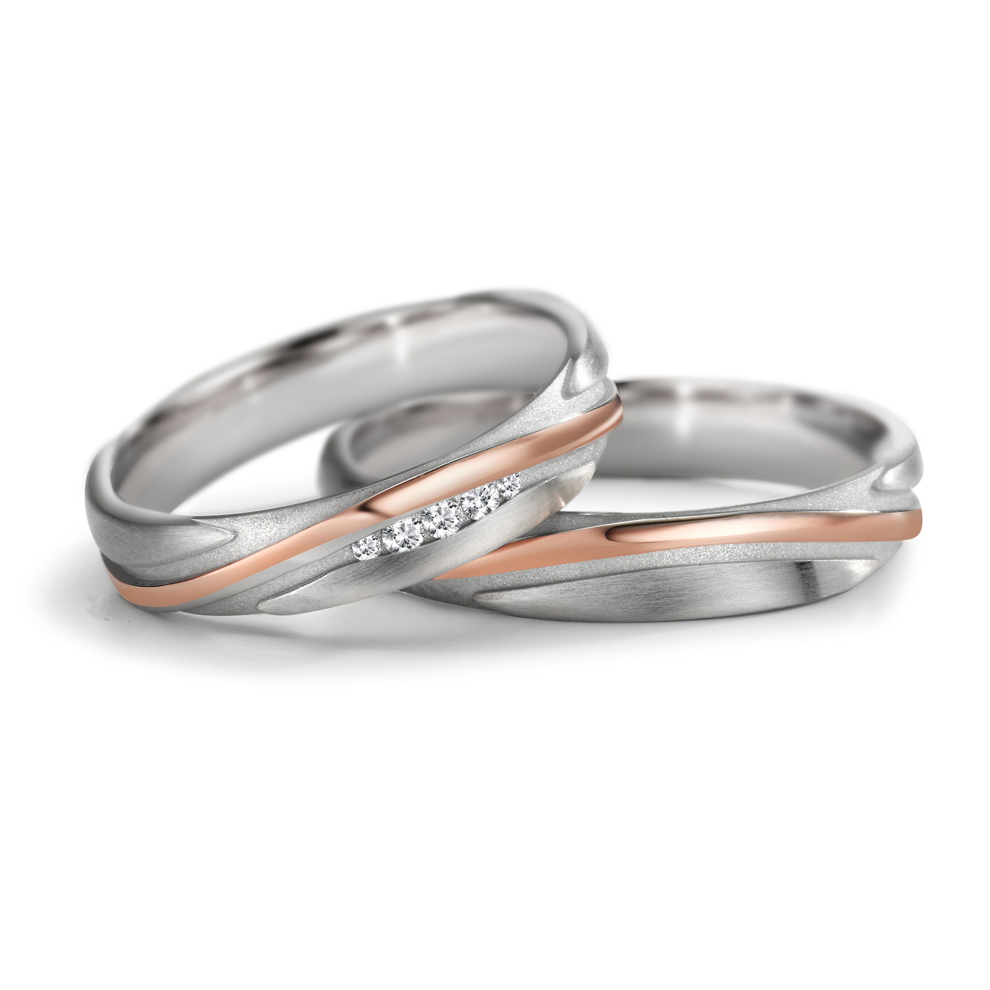 Eheringe mit schwungvoller Wellenlinie, kombiniert aus Weissgold und Roségold mit Diamantbesatz.