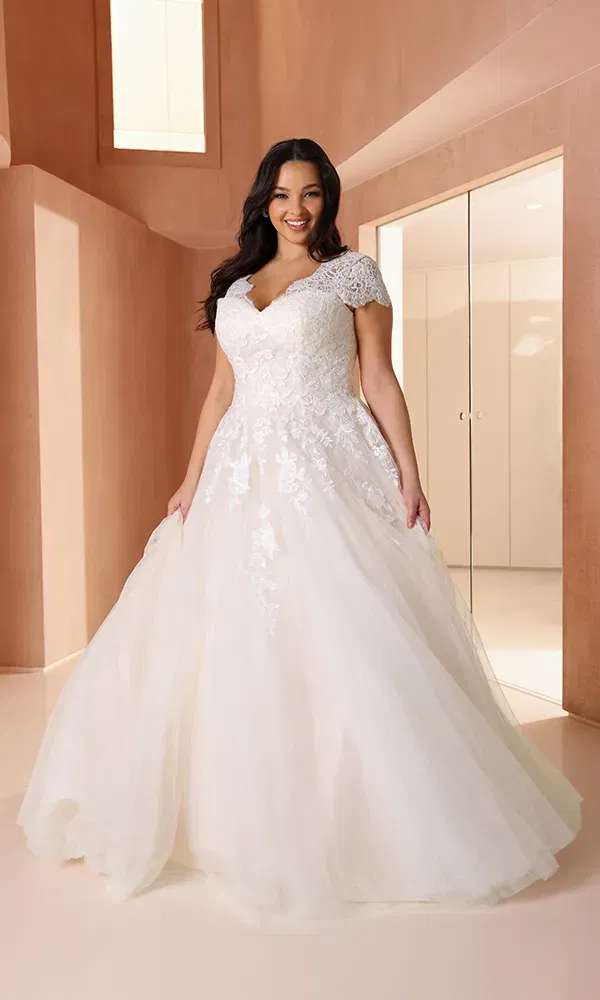 Elegantes Curvy-Brautkleid mit V-Ausschnitt, Spitzenoberteil und zartem Tüllrock – romantisch und figurschmeichelnd zugleich.