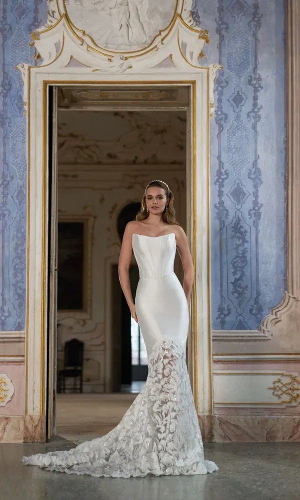 Modernes Brautkleid in Mermaid-Silhouette mit glattem Oberteil und detailreicher Spitze im Rock