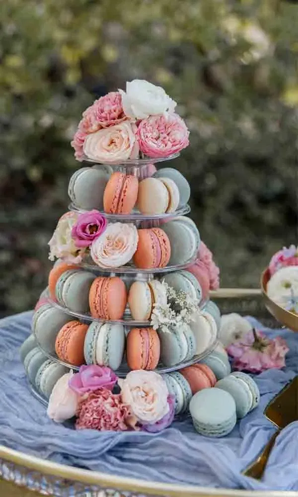 Dekorativer Macaron-Turm mit Rosendeko, liebevoll inszeniert für eine Hochzeit im Garten oder eine Outdoor-Feier.