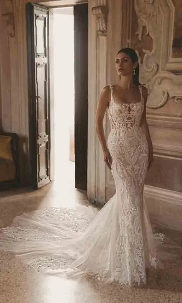 Mermaid-Brautkleid mit Trägern und Schleppe in einem prachtvollen Raum mit barocken Wandverzierungen – edel und stilvoll.