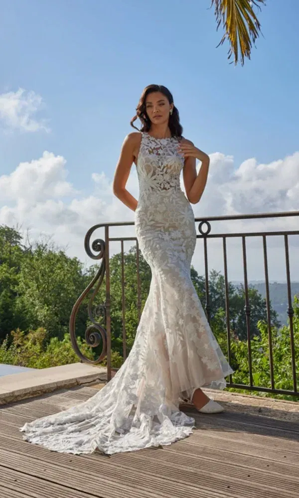 Fit-and-Flare-Brautkleid mit Schleppe und transparentem Spitzentop – Braut steht barfuß auf rustikaler Holzterrasse.