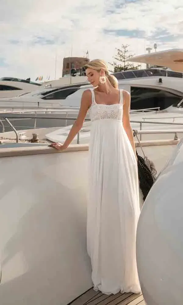 Maritime Hochzeitsstimmung mit einer Braut im fließenden Chiffonkleid im Empire-Stil, umgeben von weißen Motorbooten.