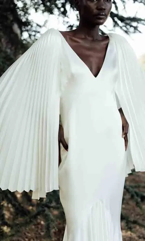 Zeitlos elegantes Hochzeitskleid mit weiten, plissierten Ärmeln und klassischem Schnitt.