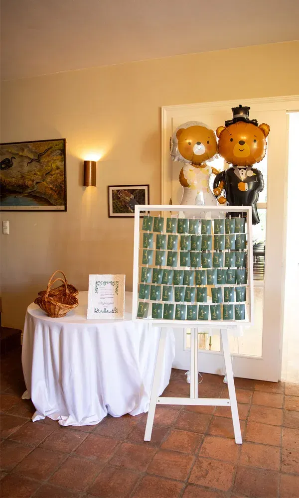 Sitzplan zur Hochzeit mit grünen Kärtchen auf Staffelei und zwei großen Bärenballons als Braut und Bräutigam.