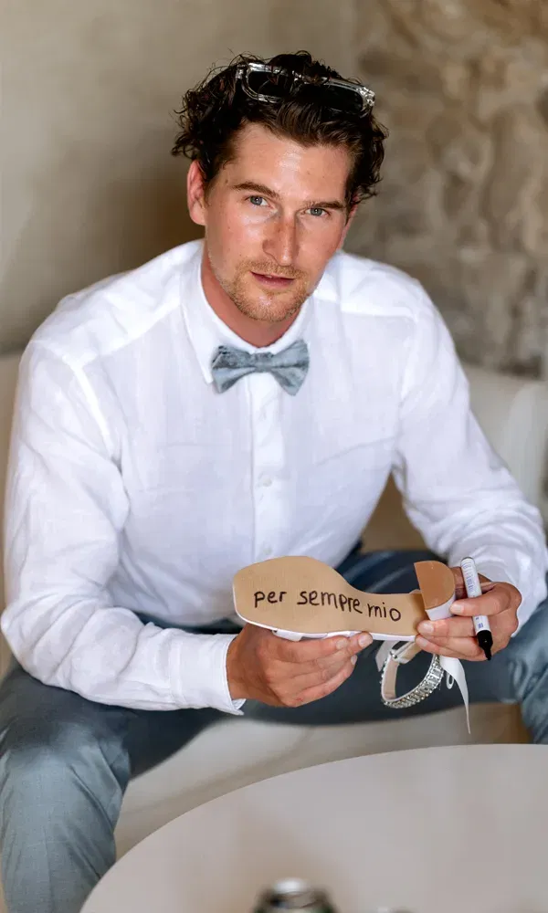 Persönlicher Hochzeitsmoment: Der Bräutigam schreibt eine italienische Liebesbotschaft auf den Schuh der Braut.