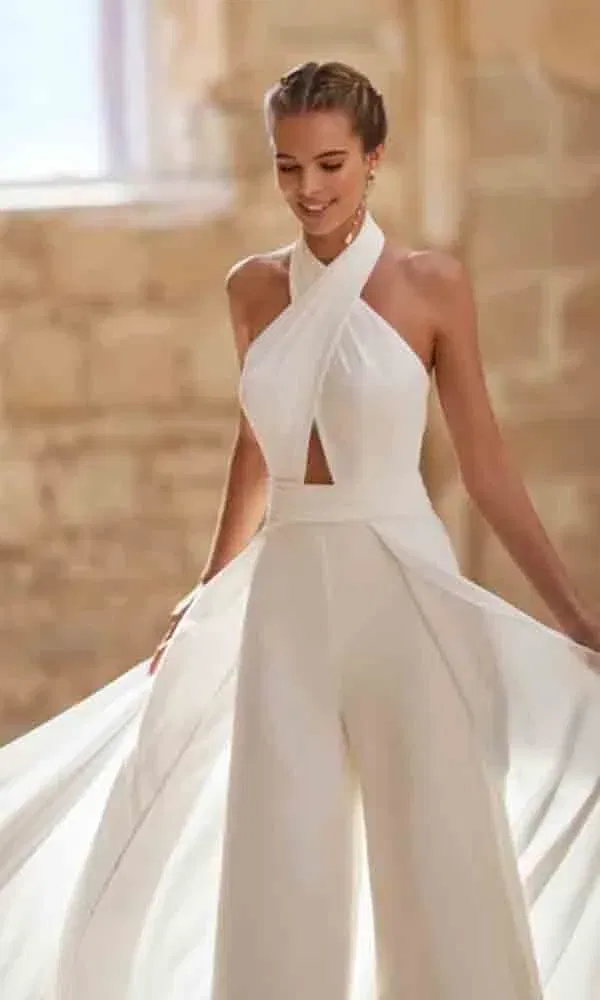 Romantischer Braut-Jumpsuit mit Halterneck und weich fallender Drapierung – stilvoll und modern im mediterranen Ambiente.