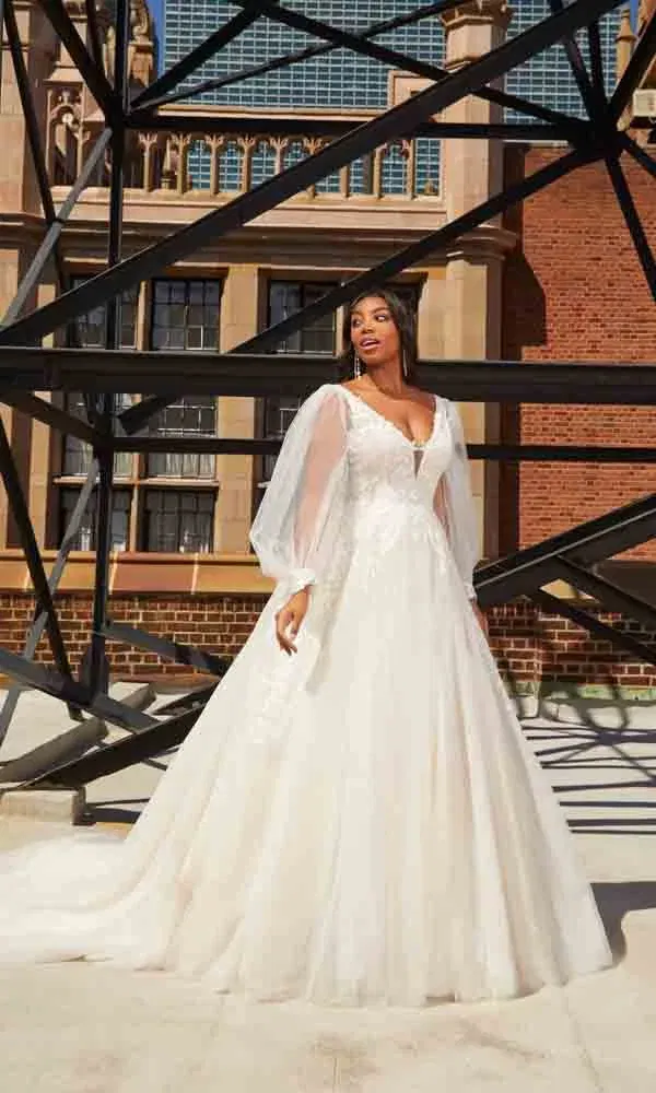 Moderne Hochzeitsszene mit Prinzessinnenkleid und zarten Ärmeln auf einem Stadtdach.