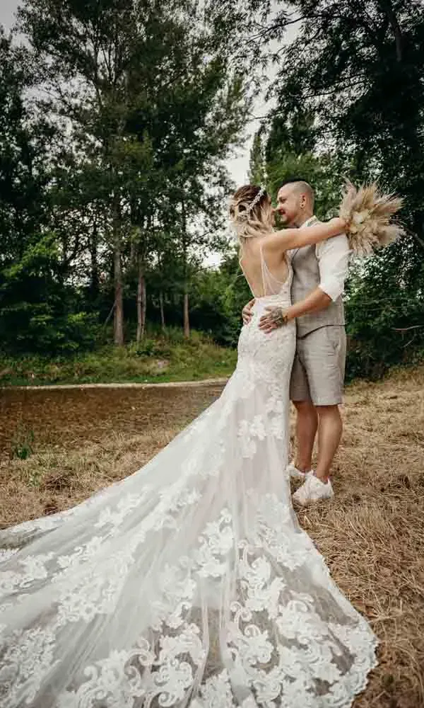 Romantisches Paarfoto in der Naturkulisse – mit besticktem Brautkleid, Boho-Dekoelementen und natürlichem Licht.