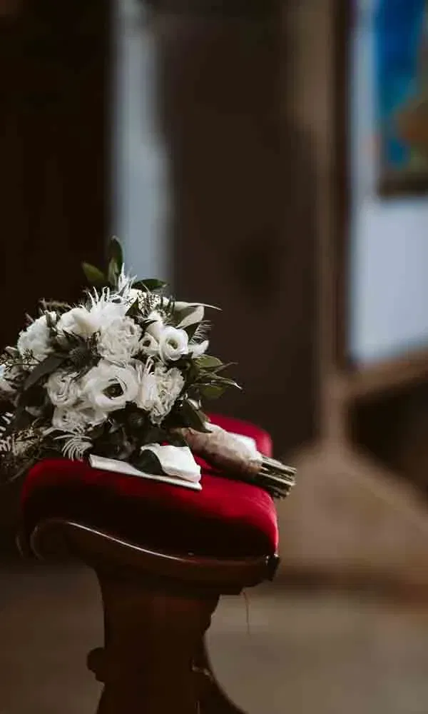 Detailaufnahme eines Brautstraußes mit natürlichen Elementen, bereit für die kirchliche Zeremonie.