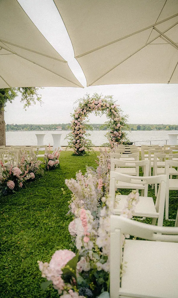 Stimmungsvolle freie Trauung am Wasser, eingerahmt von zarten Blüten.