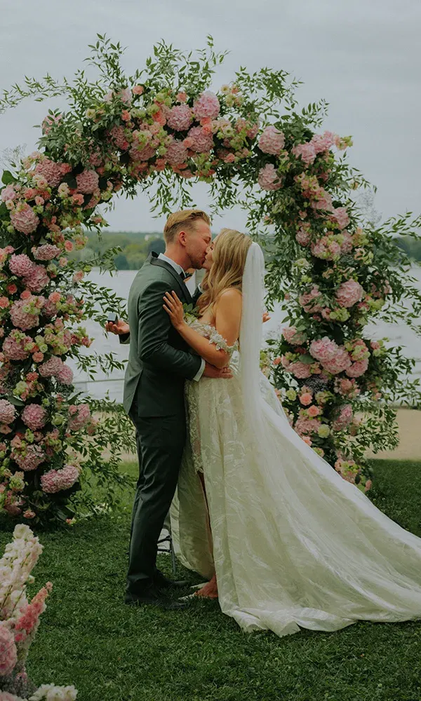 Emotionaler Moment: frisch vermähltes Paar küsst sich vor atemberaubender Kulisse.