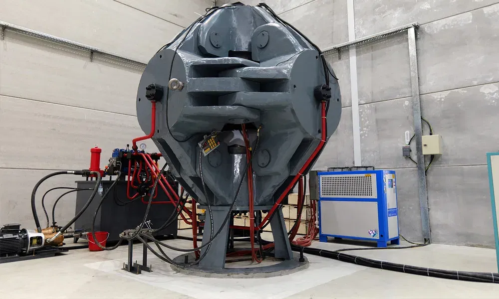 Große HPHT-Diamantenpresse in einem Laborraum mit angeschlossenen Kabeln und Geräten.