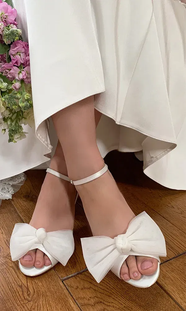 Detailaufnahme filigraner Brautschuhe aus Spitze – perfekte Wahl für einen femininen Hochzeitslook