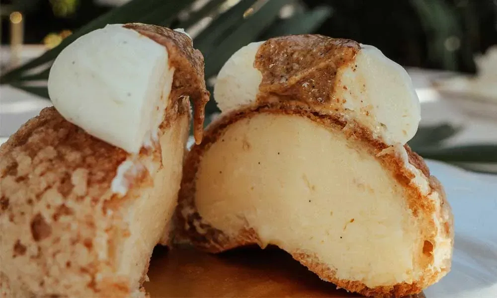 Halbiertes französisches Gebäck mit Vanillefüllung auf Dessertteller