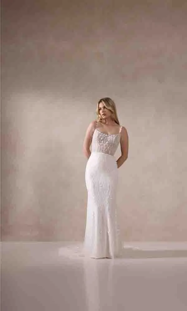 Moderne Braut in einem enganliegenden Kleid mit romantischen Spitzen-Details und transparenter Miederoptik.