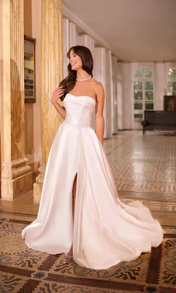 Modernes Brautkleid mit Korsage, luxuriösem Satinrock und hohem Schlitz für einen glamourösen Auftritt.