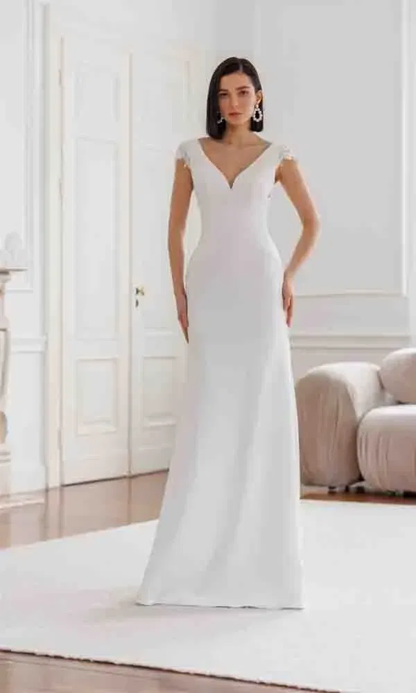 Zeitloses Brautkleid mit femininer Silhouette, V-Ausschnitt und dezenten Spitzenärmeln.