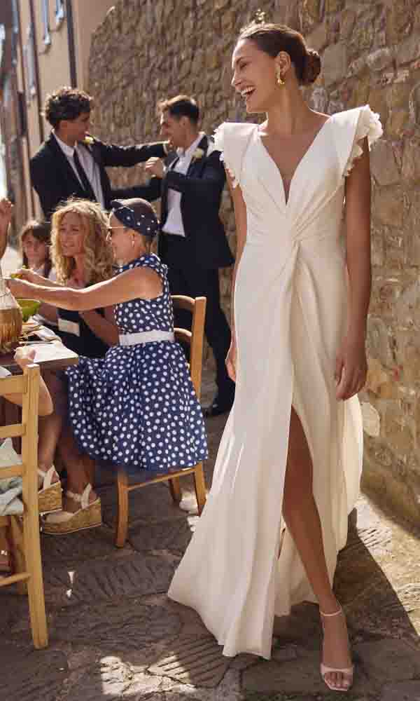 Lockeres Brautkleid im modernen Stil mit Schlitz und V-Ausschnitt bei einer festlichen Feier im Freien.