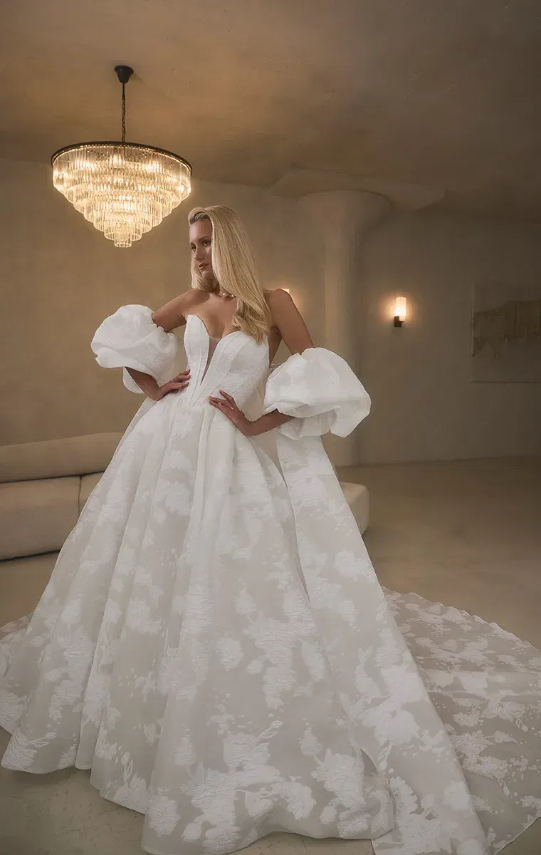 Opulentes Brautkleid von Casablanca aus Jacquard mit tiefem Dekolleté und voluminösen Statement-Ärmeln.