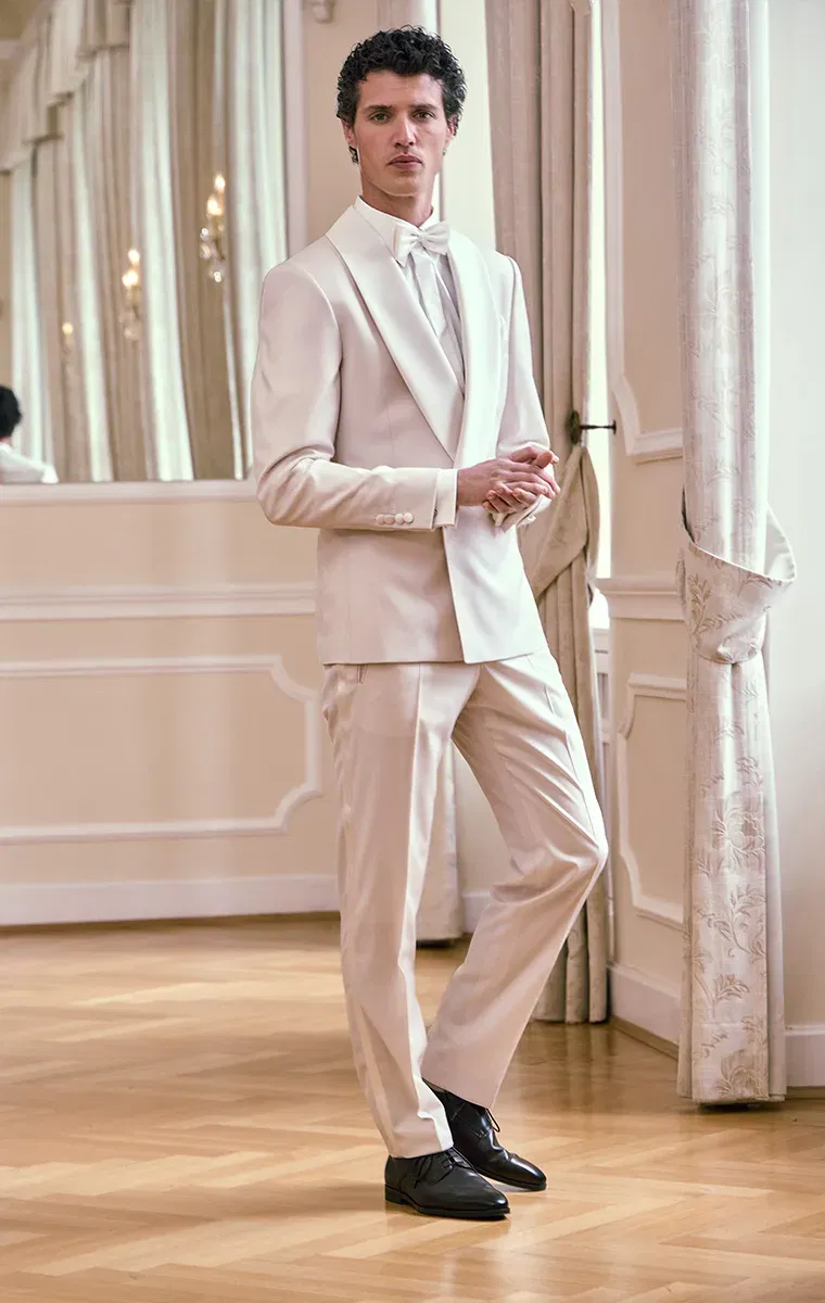 Bräutigam im eleganten weißen Dinner Jacket mit Fliege – stilvoller Gentlemanlook für moderne Bräutigamfashion.