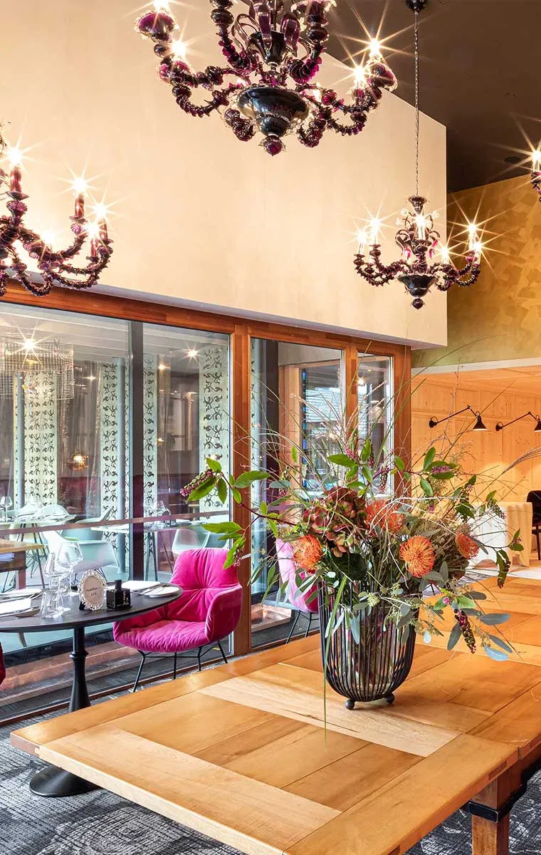 Elegantes Interieur im Genießerhotel GAMS zu zweit mit stilvollen Kronleuchtern, Blumenarrangement und gemütlicher Atmosphäre.