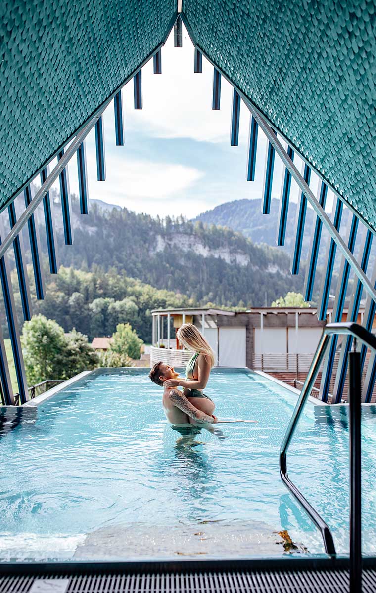 Romantischer Moment im Sky-Pool des Hotels GAMS in Bezau – Paar genießt Wellness mit Blick auf die Berge.