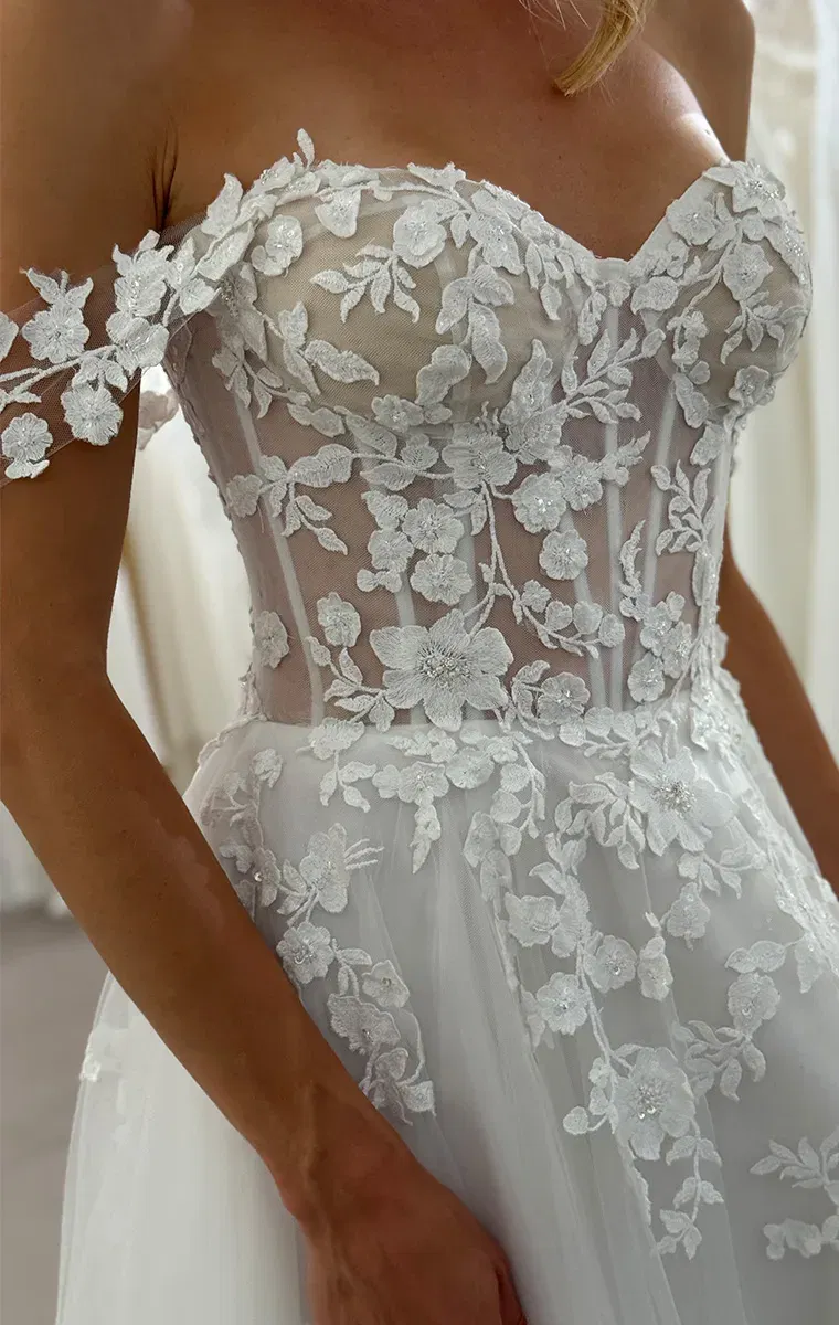 Detailansicht eines maßgeschneiderten Casablanca Brautkleids mit floraler Spitze und transparenter Corsage.