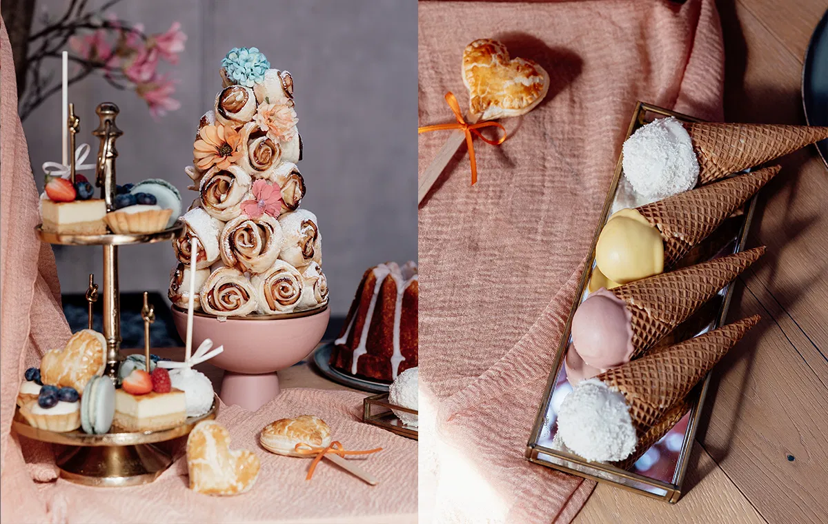 Detailaufnahme eines Sweet Tables mit Zimtschnecken-Turm, Gebäck und farbigen Eistüten – perfekt für eine Hochzeit im natürlichen Stil.