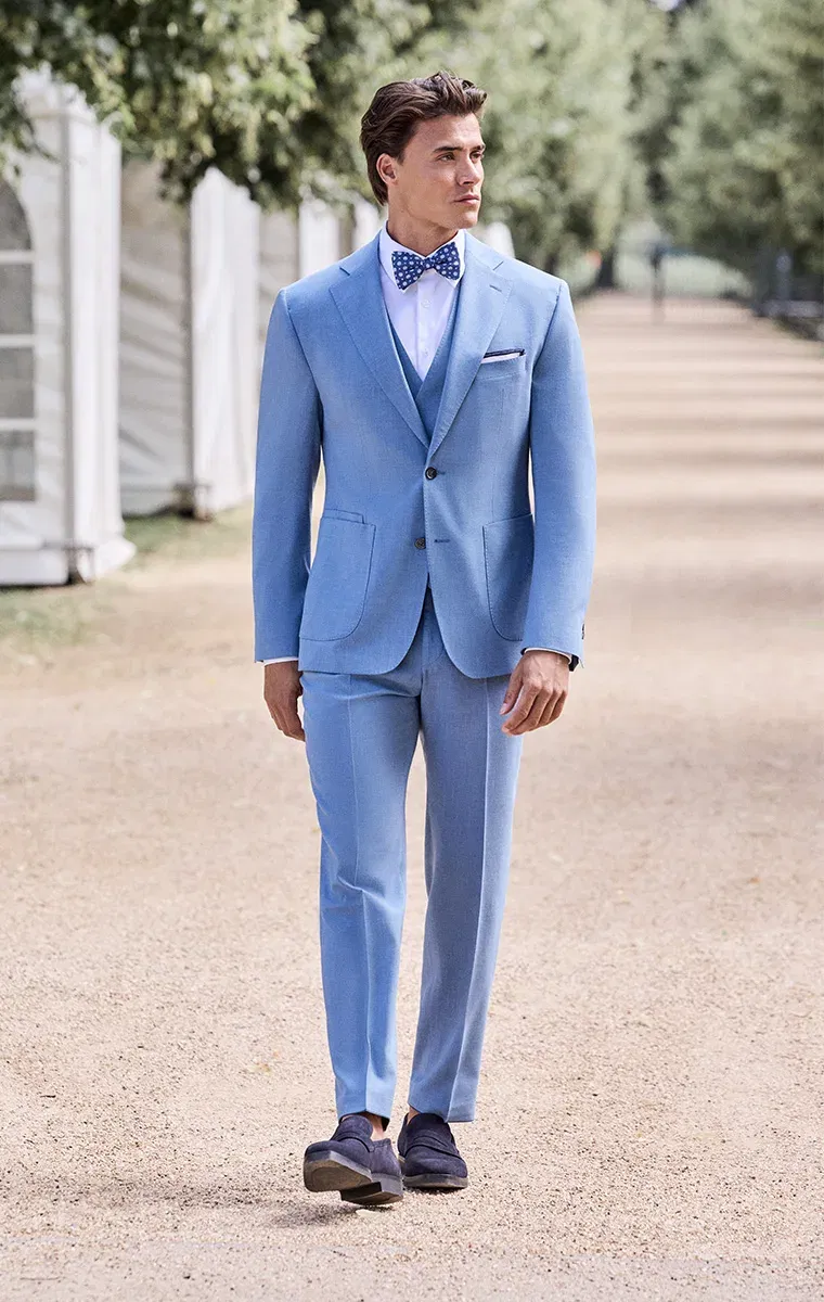 Hellblauer Hochzeitsanzug mit Weste und gepunkteter Fliege – moderner Look für stilbewusste Bräutigame im Freien.
