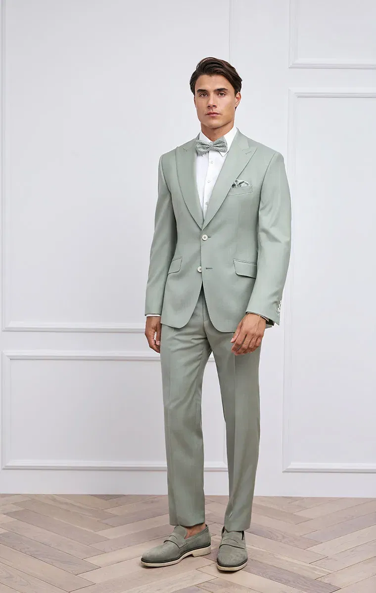 Bräutigam im mintgrünen Hochzeitsanzug mit Fliege – stilvoller Look für sommerliche Hochzeiten.