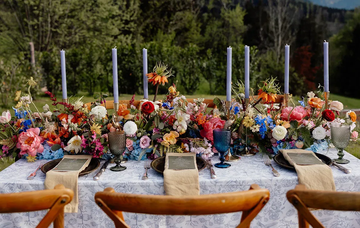 Aufwendig gedeckte Hochzeitstafel mit buntem Blumenschmuck und Kerzen – inspiriert von einer Nature Wedding.