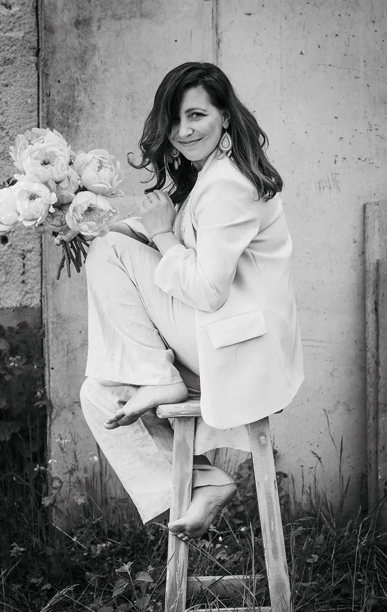 Künstlerisches Schwarz-Weiß-Porträt einer Frau mit Blumenstrauß – natürliche Eleganz und Kreativität.