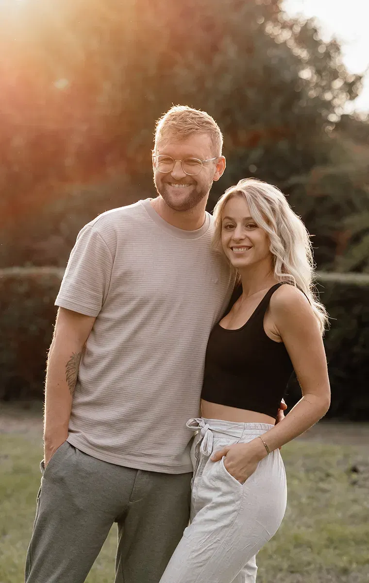 Lächelndes Paar im warmen Abendlicht – moderne Hochzeitsfotografen bei einer Outdoor-Session.