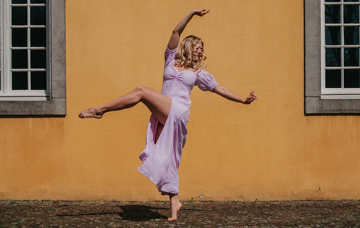 Eine Tänzerin in Pose vor einer Hauswand
