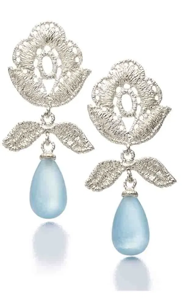 Filigrane Silberohrringe mit floralen Elementen und hellblauen Tropfenanhängern.