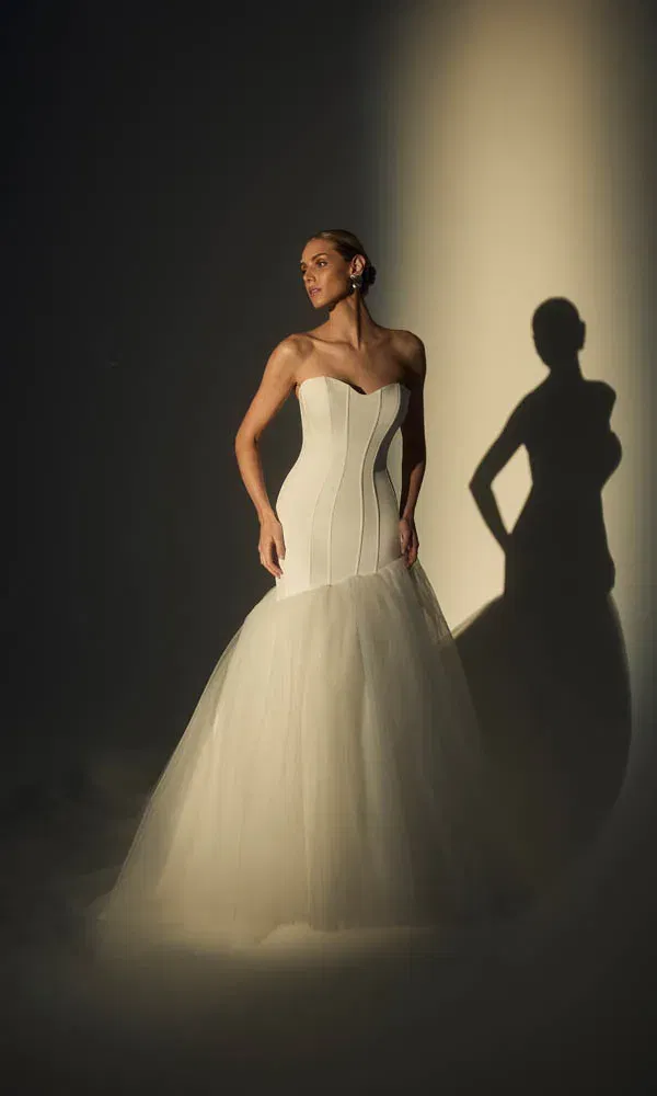 Schlichtes, elegantes Brautkleid mit herzförmigem Ausschnitt und Tüllrock, inszeniert im Studio-Lichtspiel.