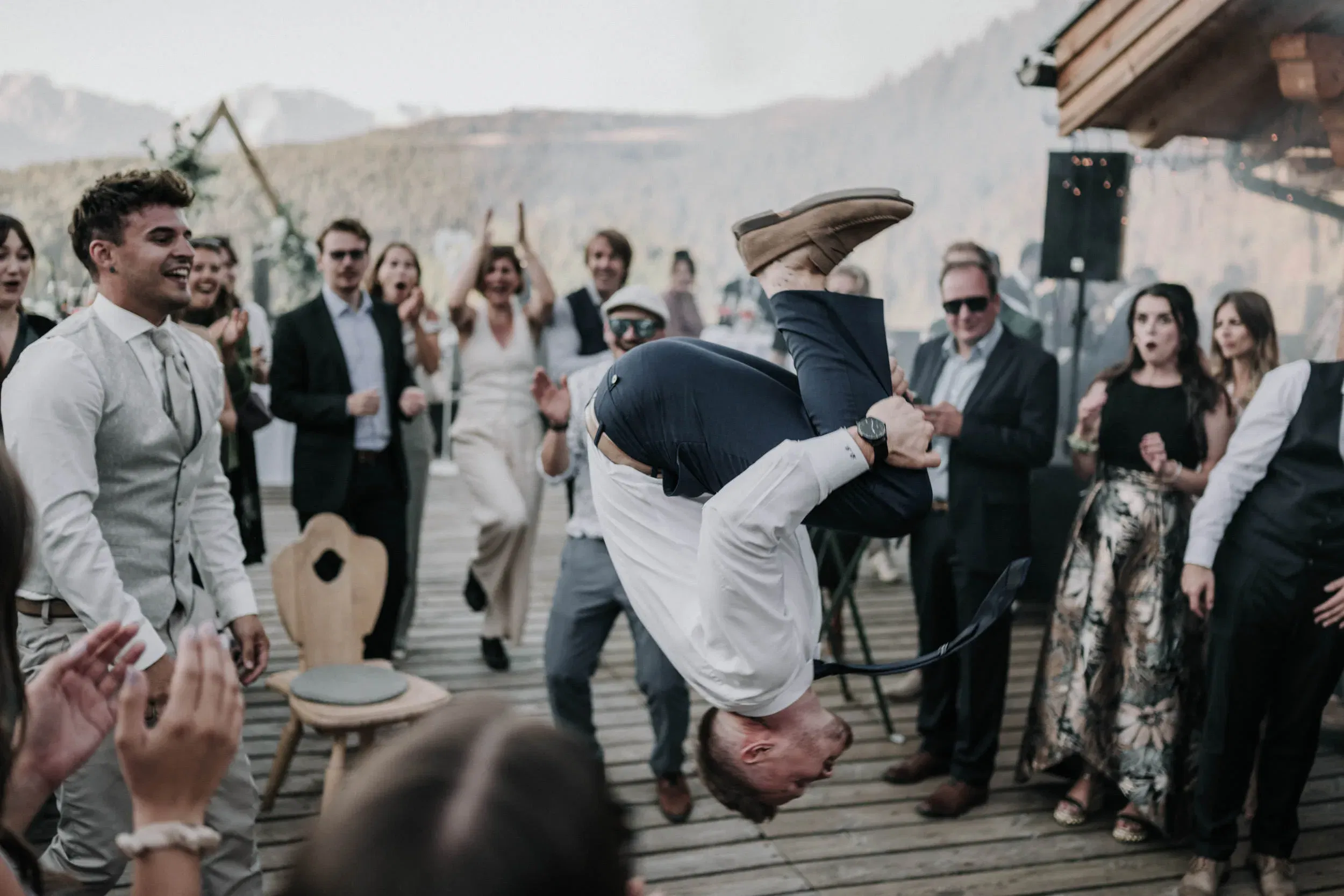 Ein Gast zeigt einen spektakulären Überschlag auf der Tanzfläche, während die Hochzeitsgesellschaft begeistert jubelt.