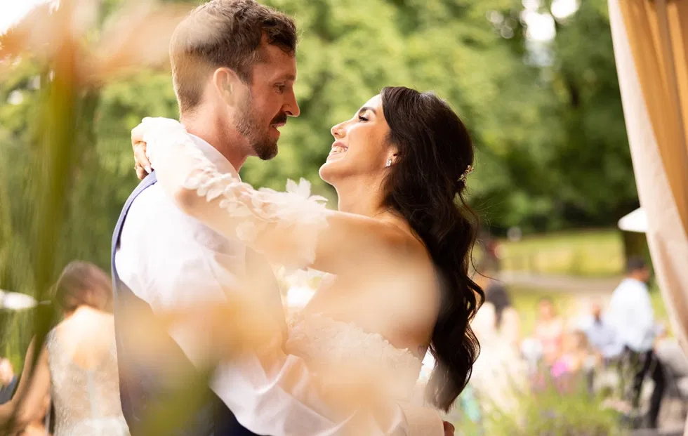 Romantischer Hochzeitstanz des Brautpaares im Freien, eingefangen in einem intimen Moment voller Nähe und Emotionen.