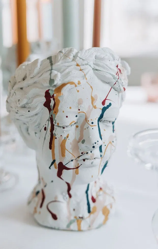 Künstlerische Vase im Artsy-Wedding-Stil mit farbigen Farbklecksen, die an ein abstraktes Kunstwerk erinnern und moderne Hochzeitsdeko zeigen.