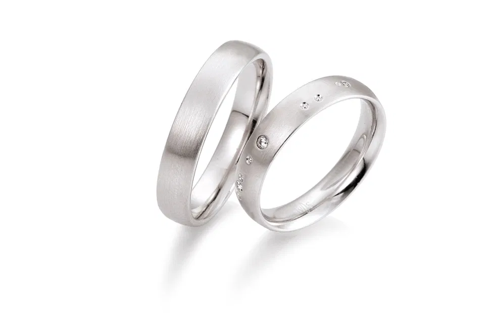 Zeitloses Trauringpaar aus Weißgold mit dezent gefassten Diamanten von Saint Maurice.