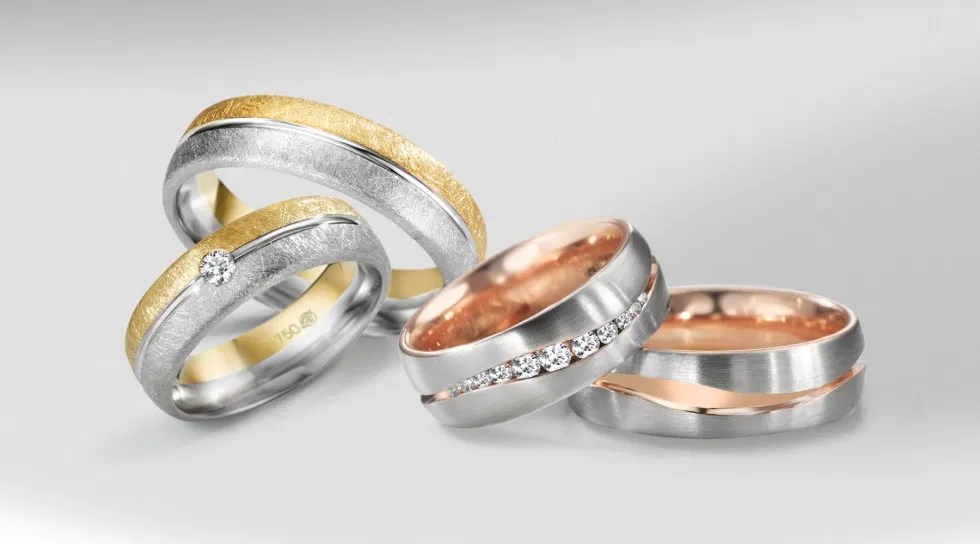 Bicolor Trauringe aus Gelbgold und Weißgold mit Diamantbesatz – moderne Eheringe mit gebürsteter Oberfläche.