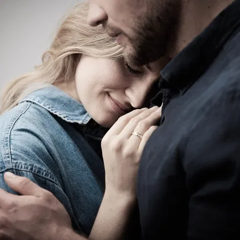 Verliebtes Paar in Umarmung mit sichtbarem Ehering – emotionales Lifestyle-Motiv rund um Verlobung und Hochzeit.