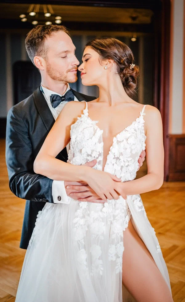 Nahaufnahme eines eleganten Brautpaars beim Tanz, der Bräutigam hält die Braut sanft im Arm, während sie sich innig zueinander neigen.